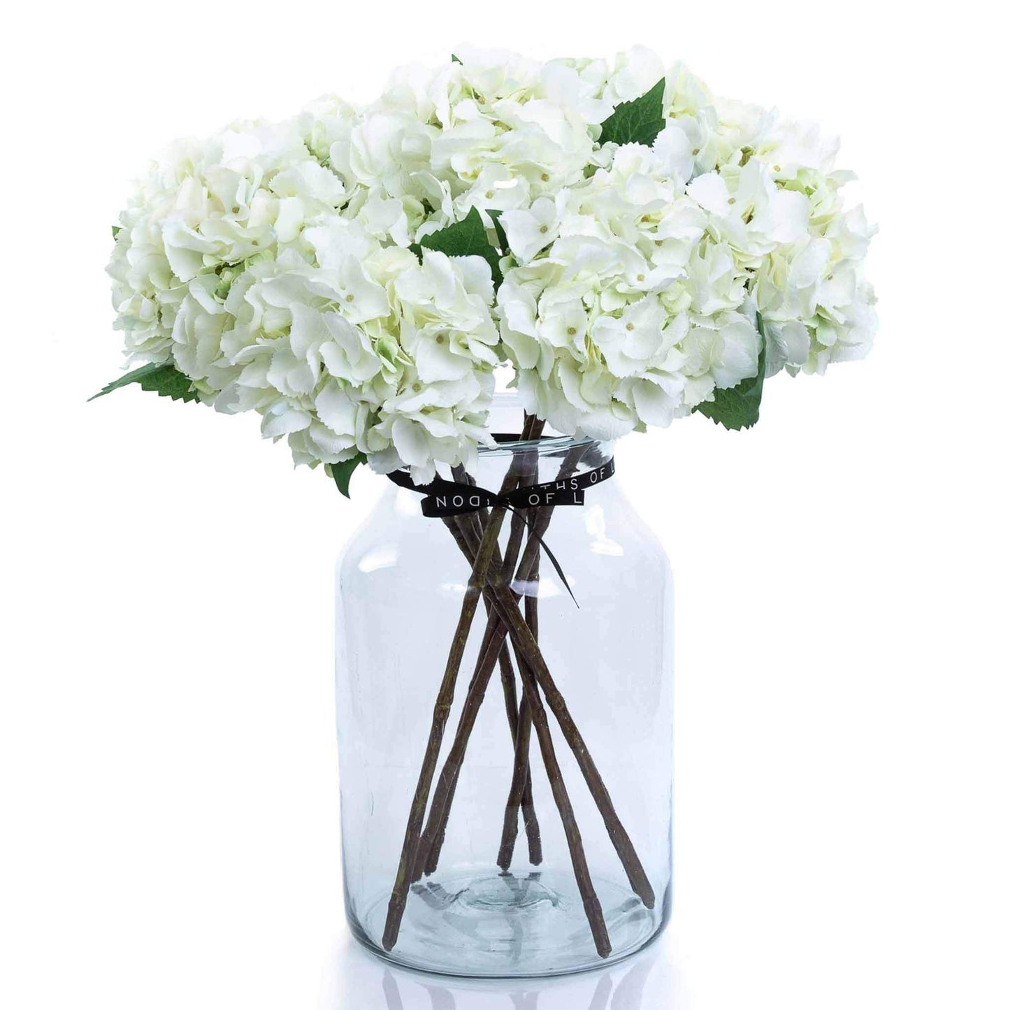 Large faux white hydrangea bouquet in apothecary vase